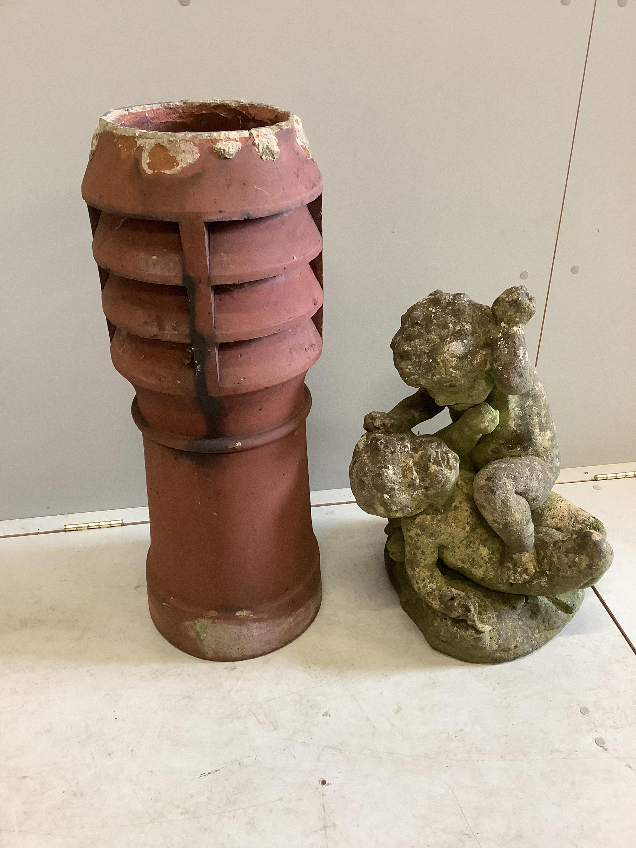 A reconstituted stone fighting cherub garden ornament, height 56cm, together with a terracotta chimney pot planter
